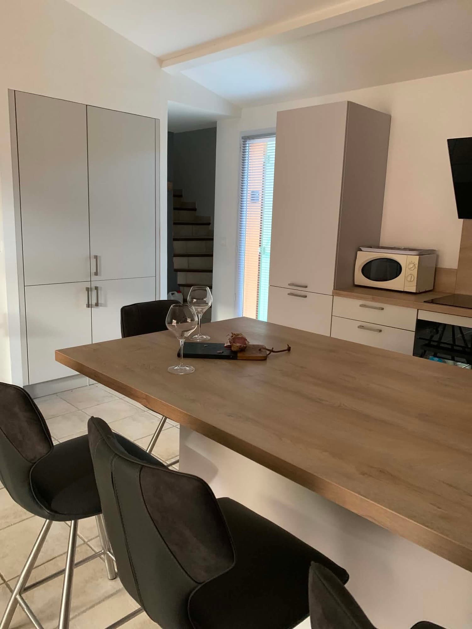 Îlot central de la cuisine de la Villa Dypsis avec bar et tabourets