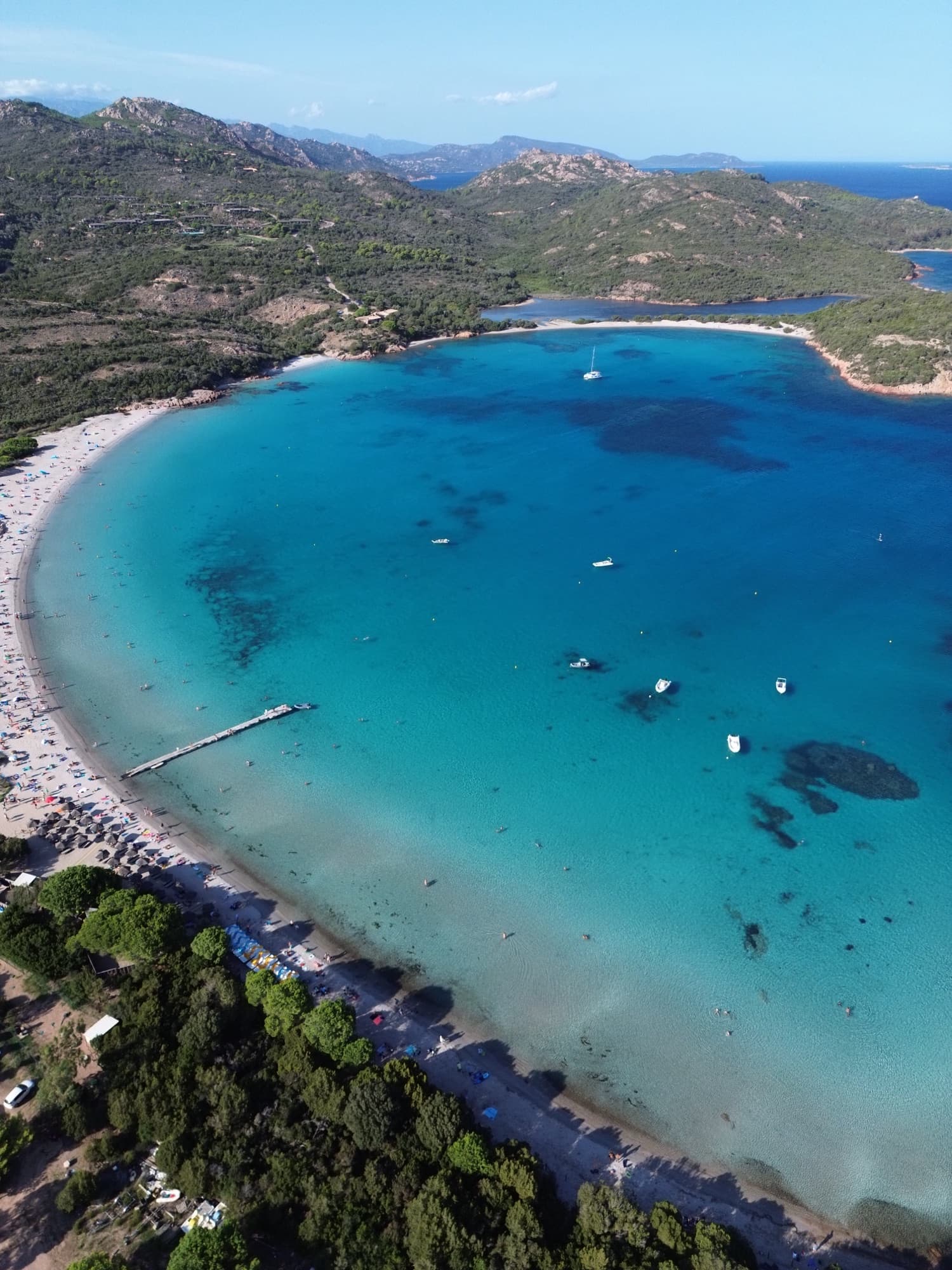 Vue aérienne de la baie de Santa Giulia, eau turquoise et bateaux au mouillage
