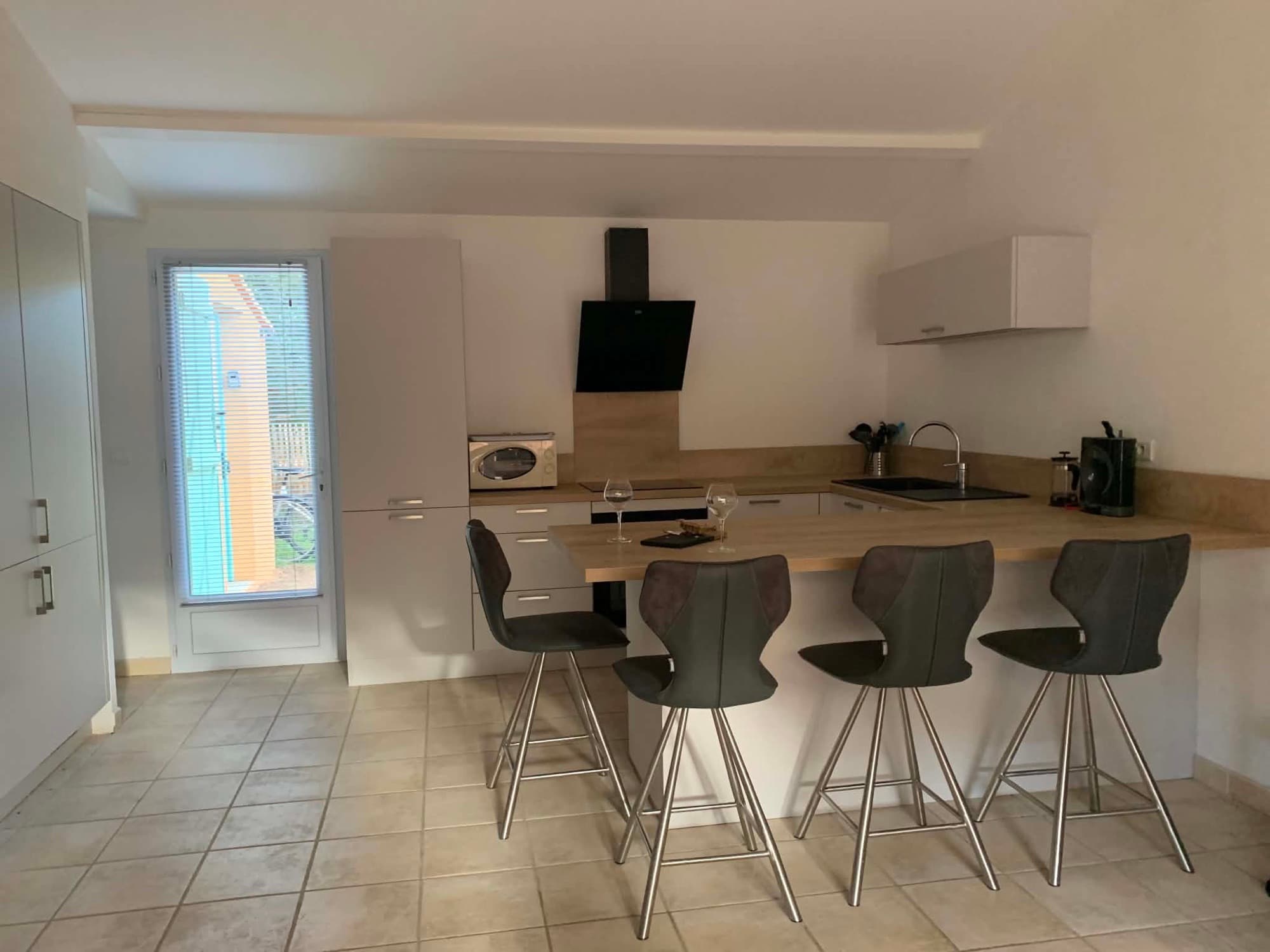Cuisine équipée de la Villa Dypsis avec hotte et plan de travail en bois