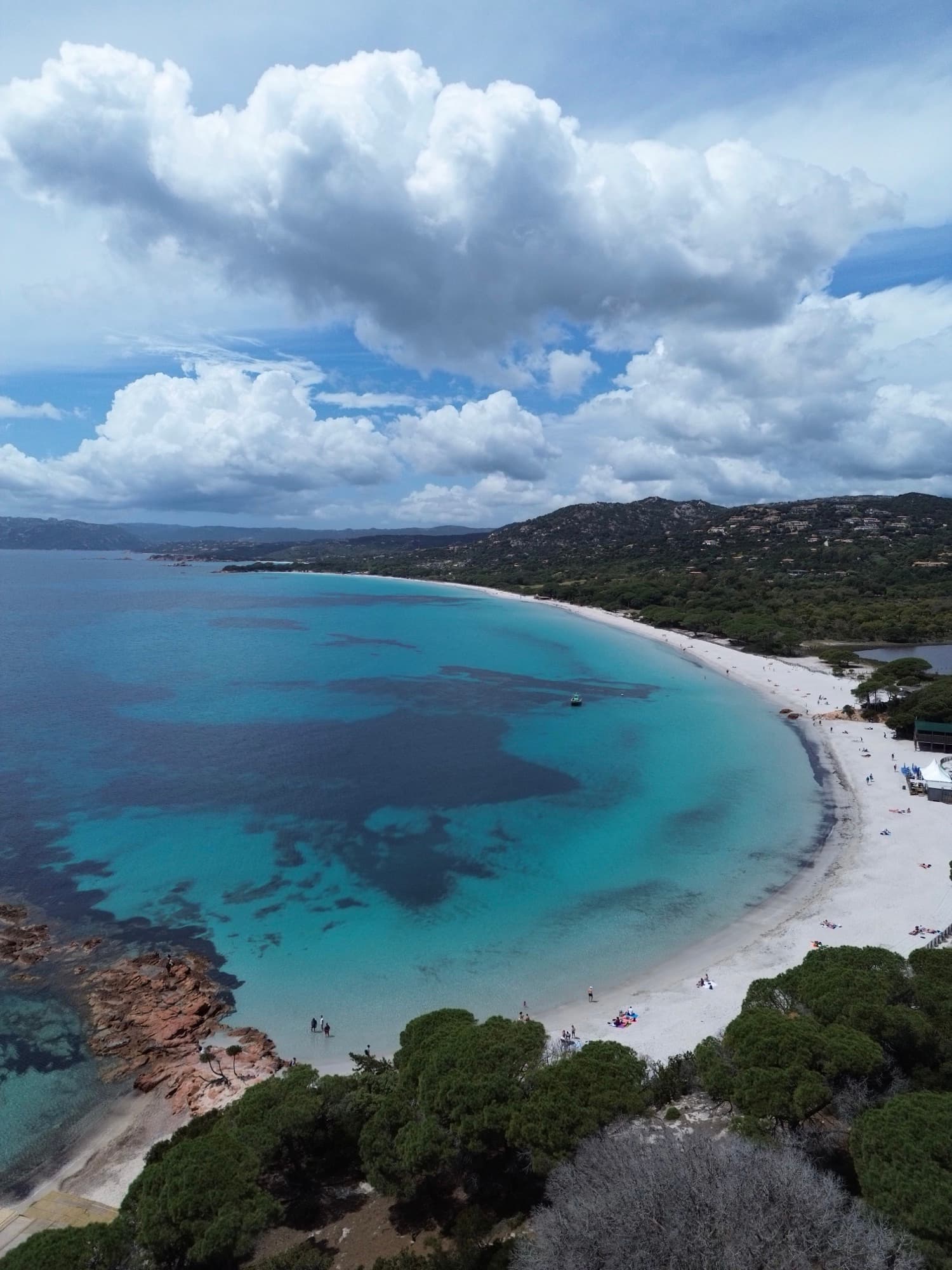 Vue aérienne de la plage de Palombaggia avec eau turquoise cristalline, rochers de granit rose et pins parasols
