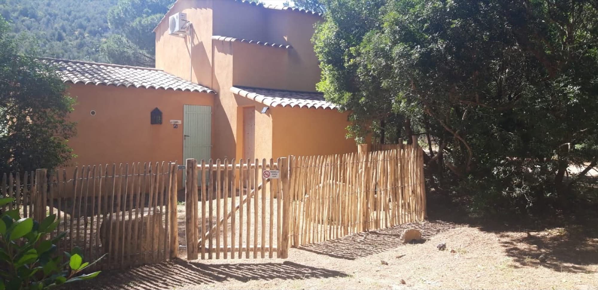 Vue extérieure de la Villa Dypsis avec sa façade ocre et son jardin clôturé